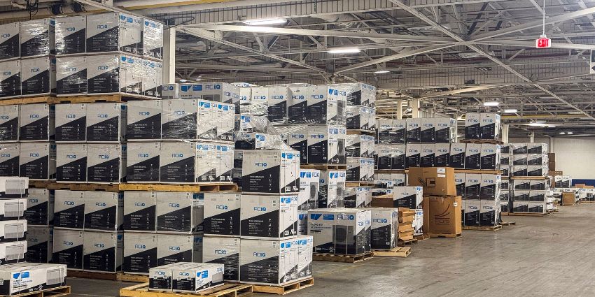 ACiQ HVAC warehouse with stacked pallets of packaged HVAC systems and inventory ready for shipping