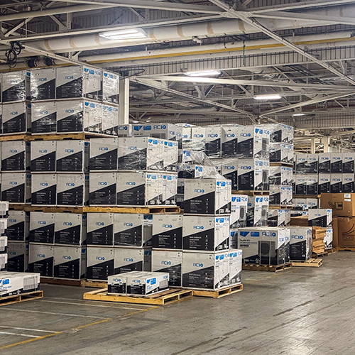 Warehouse stocked with ACiQ HVAC systems on pallets showing inventory availability and fast shipping capability