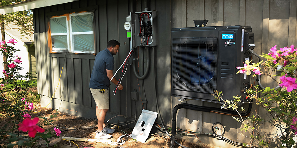 HVAC technician installing ACiQ heat pump system for upselling opportunities