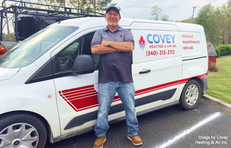 David Covey standing in front of a Covey Heating & Air service van.